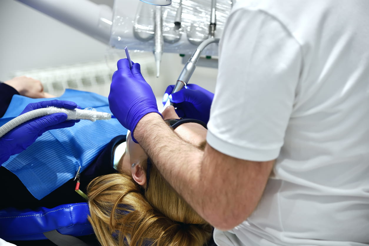 A dentist examines a patient